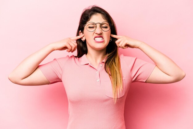 Coprire le orecchie con le dita stressate e disperate da un ambiente rumoroso