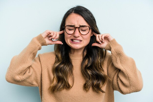 Coprire le orecchie con le dita stressate e disperate da un ambiente rumoroso