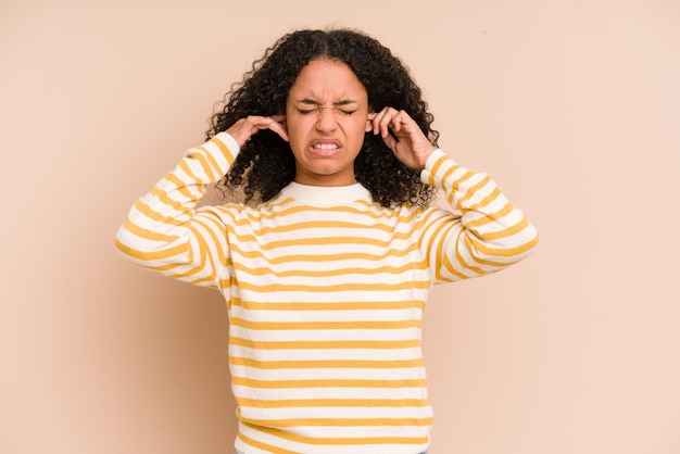 Coprire le orecchie con le dita stressate e disperate da un ambiente rumoroso