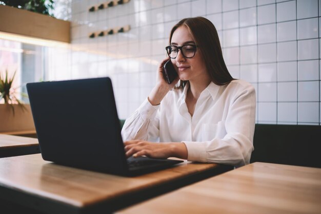 Copywriter professionista che si gode il lavoro a distanza mentre è seduto al bar e parla con un amico