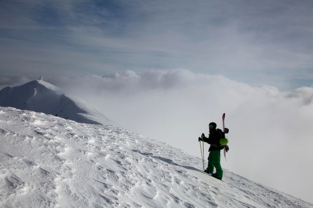 Coraggioso escursionista sul bordo della montagna con sfondo naturale di cielo e nuvole Copertura nuvolosa sulle montagne