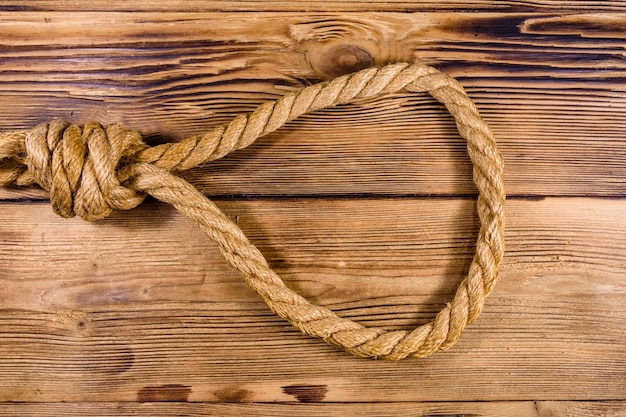 Corda con cappio per il suicidio su fondo di legno