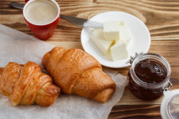 Cornetti, burro e caffè su un tavolo di legno