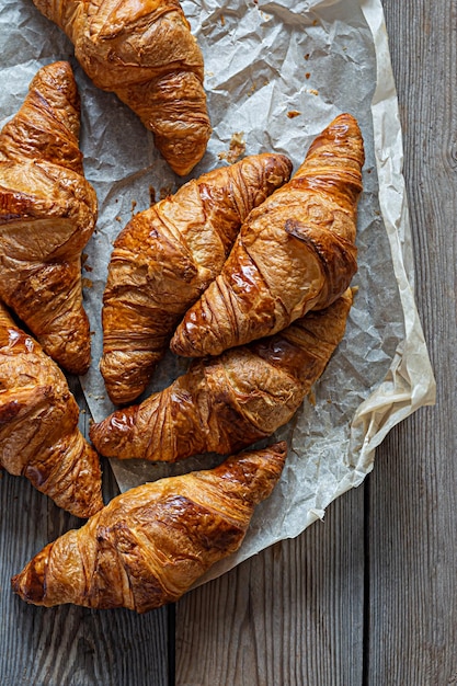 Cornetti francesi croccanti freschi su un fondo di legno. Pasta sfoglia rossa tradizionale (panini)