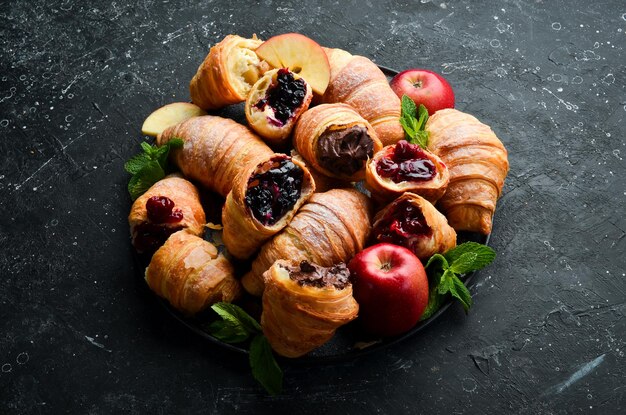 Cornetti tradizionali con marmellata, cioccolato e mela. Dolci pasticcini. Vista dall'alto. Stile rustico.