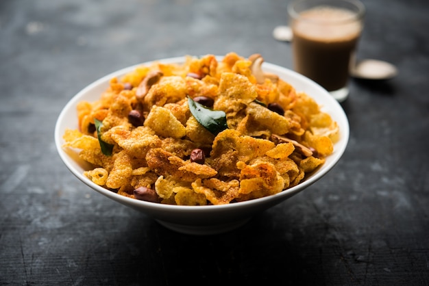 Cornflake Chivda o Corn Chiwda caricato con arachidi e anacardi. Servito in una ciotola. messa a fuoco selettiva