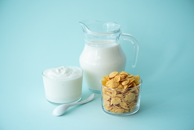 Cornflakes con yogurt greco latte e frutti di bosco su sfondo blu