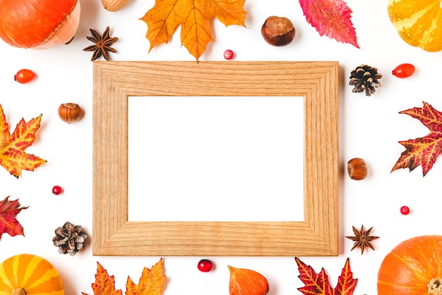 Cornice autunnale fatta di foglie d'autunno, zucche, fiori, bacche e noci isolati