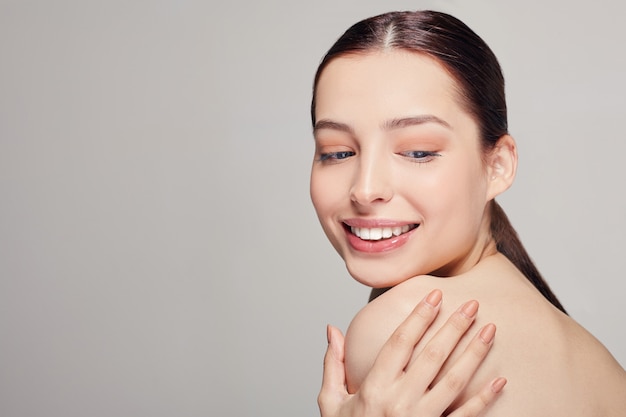 Cornice centrale giovane bella donna tenera con labbra carnose e un umore giocoso tiene la mano sinistra sulla spalla