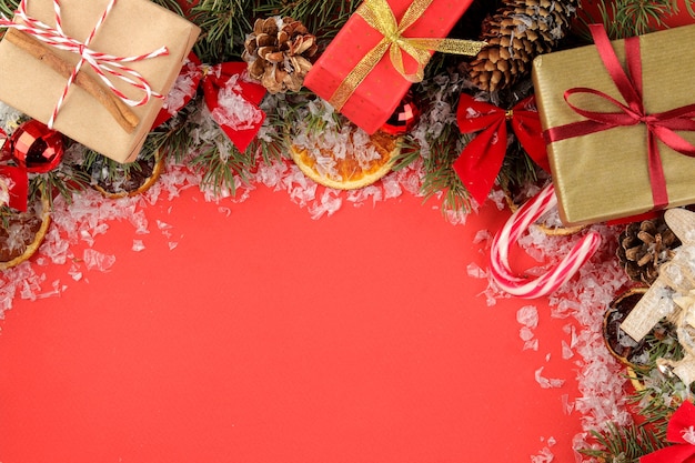 cornice con un albero di Natale e decorazioni colorate su sfondo rosso brillante