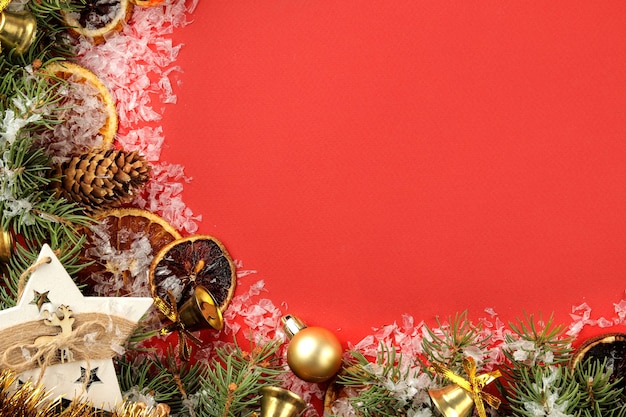 cornice con un albero di Natale e decorazioni colorate su sfondo rosso brillante