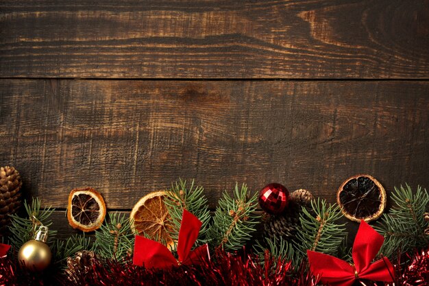 cornice con un albero di Natale e decorazioni natalizie colorate su fondo marrone