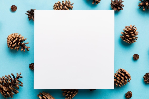 Cornice creativa fatta di pigne di Natale con carta quadrata vuota Tema Natale e Capodanno Spazio per la copia vista dall'alto piatto