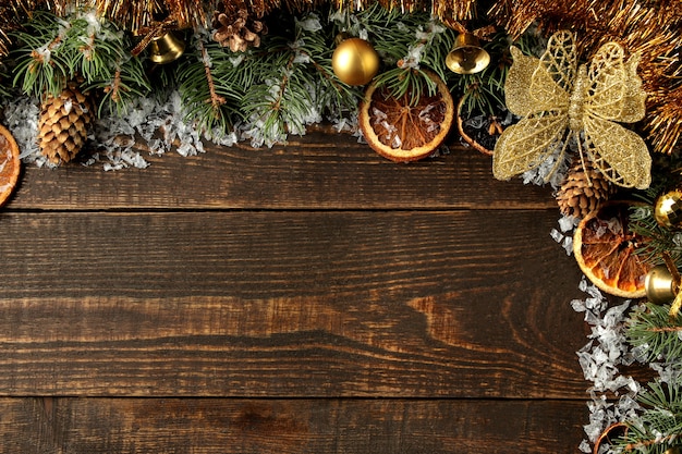 Cornice di Capodanno con un albero di Natale e decorazioni natalizie colorate su fondo marrone