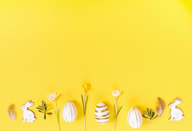 Cornice di confine festiva di Pasqua da uova di Pasqua e croco di fiori di primavera su sfondo giallo elegante e