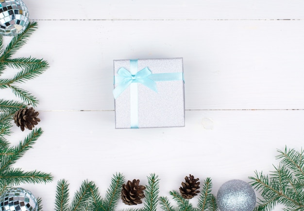 Cornice di decorazioni natalizie su sfondo bianco, rami di alberi, coni, regali Flatlay, CopySpace