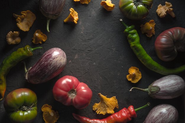 Cornice di finferli peperoncino e verdure su un tavolo grigio