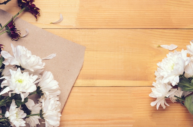 Cornice di fiori di crisantemo bianco e rosso su carta artigianale.