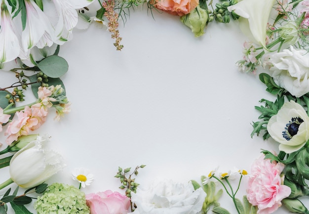 Cornice di fiori freschi su sfondo bianco