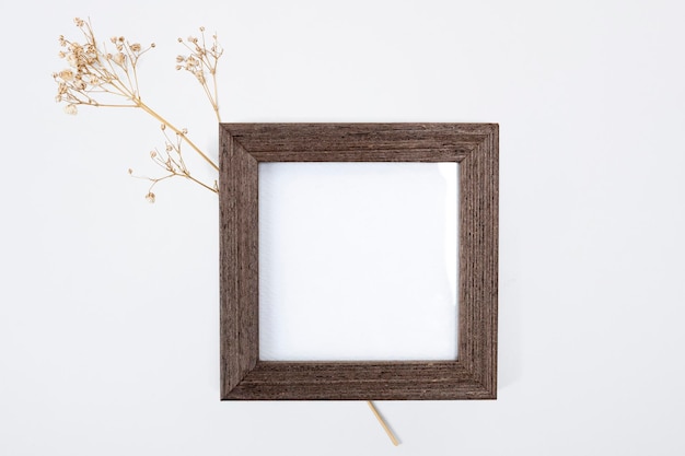 Cornice di legno con un fiore asciutto estetico