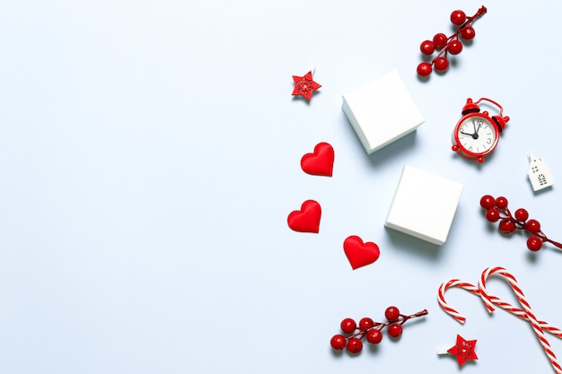 Cornice di Natale e Capodanno di bacche rosse, orologio, forma d'amore, bastoncino di zucchero, scatole bianche e stella