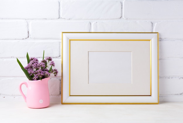 Cornice di paesaggio decorata in oro con fiori viola in brocca rustica rosa