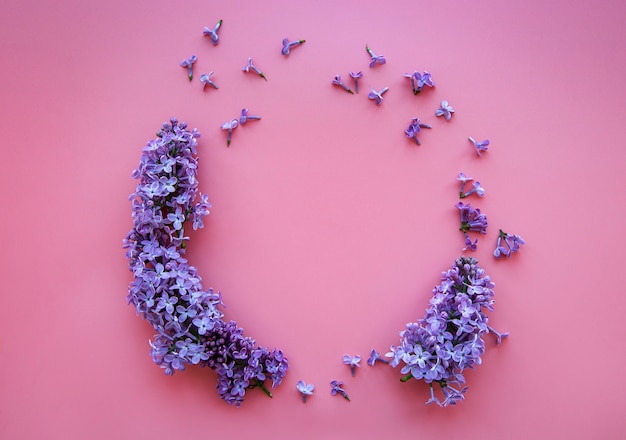 Cornice di rami e fiori di lilla su una rosa a forma di cerchio