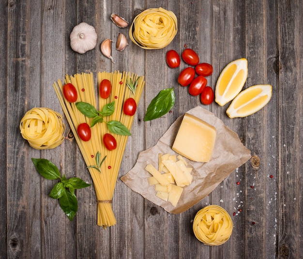 Cornice di sfondo di pasta con ingredienti per cucinare su vista dall'alto in legno stagionato