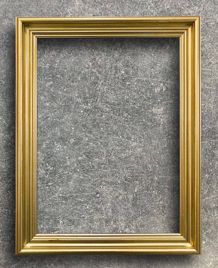 Foto cornice dorata d&#39;epoca sulla parete di cemento ruggine