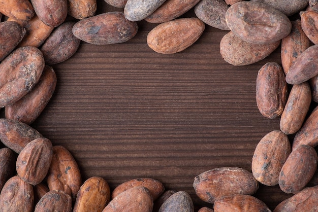 Cornice fatta di fave di cacao su tavolo di legno scuro