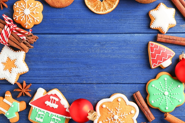 Cornice fatta di gustosi biscotti di Natale su fondo in legno