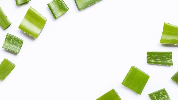 Cornice fatta di pezzi tagliati di aloe vera su sfondo bianco.