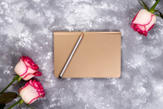 Cornice floreale: bouquet di rose bianche rosa su sfondo di pietra con copia spazio per il testo.