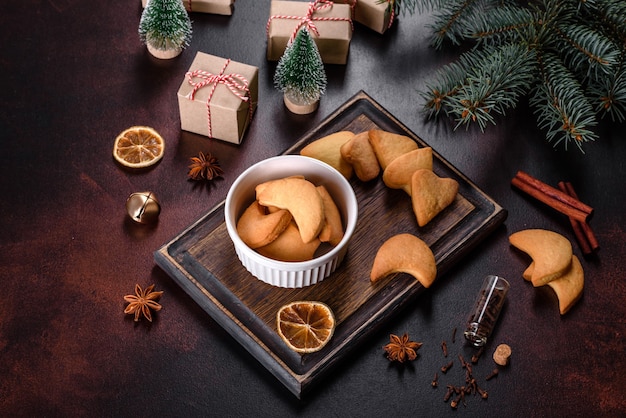 Cornice natalizia con rami di abete, biscotti di panpepato, spezie e anelli di arancia essiccata