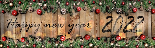 Cornice panoramica di decorazioni natalizie con felice anno nuovo 2022 scritto in mezzo su una tavola