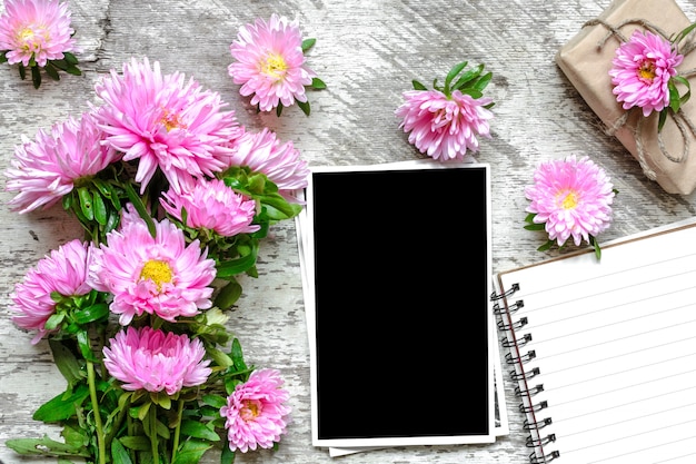 Cornice per foto in bianco e taccuino di carta con fiori di aster rosa e confezione regalo