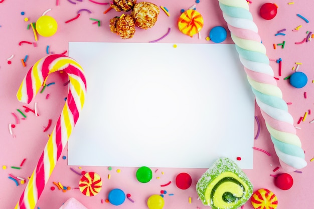 Cornice per il testo sullo sfondo di diversi, zucchero, dolci per bambini. Caramelle su uno sfondo rosa.