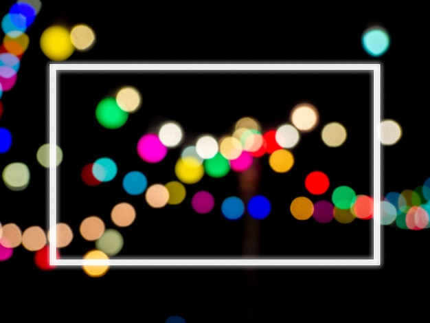 Cornice quadrata bianca con spazio vuoto sull'immagine sfocata astratta della luce colorata del bokeh della festa notturna su sfondo scuro Modello su sfondo sfocato del festival e della celebrazione del bokeh