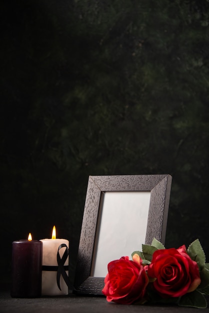 Cornice vista frontale con fiori rossi e candele sul male funebre di morte di guerra pavimento scuro