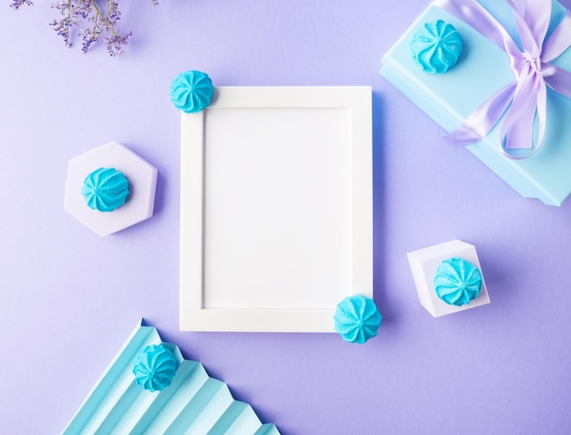 Cornice vuota bianca su sfondo viola con decorazioni dolci blu