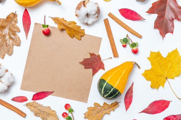 Cornice vuota di carta artigianale e foglie autunnali, cotone, zucca, sfondo di cannella. Modello autunnale. Composizione autunnale, concetto di caduta. Disposizione piatta, vista dall'alto e spazio di copia