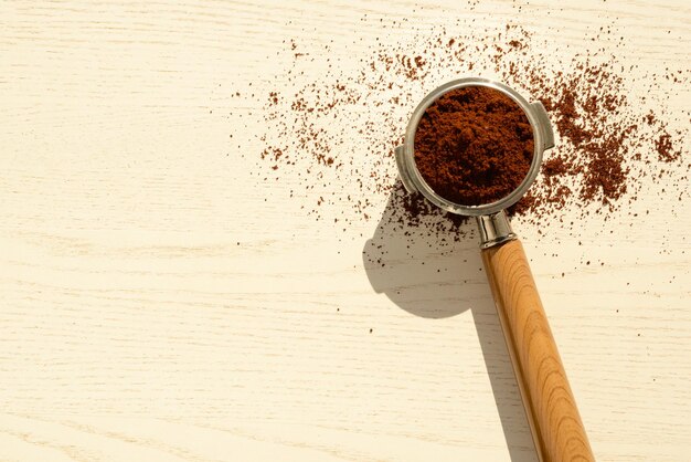 Corno da caffè con caffè macinato su un tavolo di legno bianco caffè in polvere