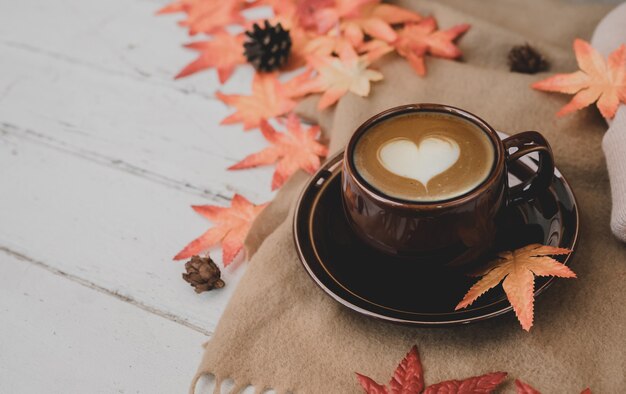 Cornucopia del raccolto autunnale. Tazza di tè caldo alla mela per bevanda calda stagione autunnale. Copia spazio su uno sfondo di legno.