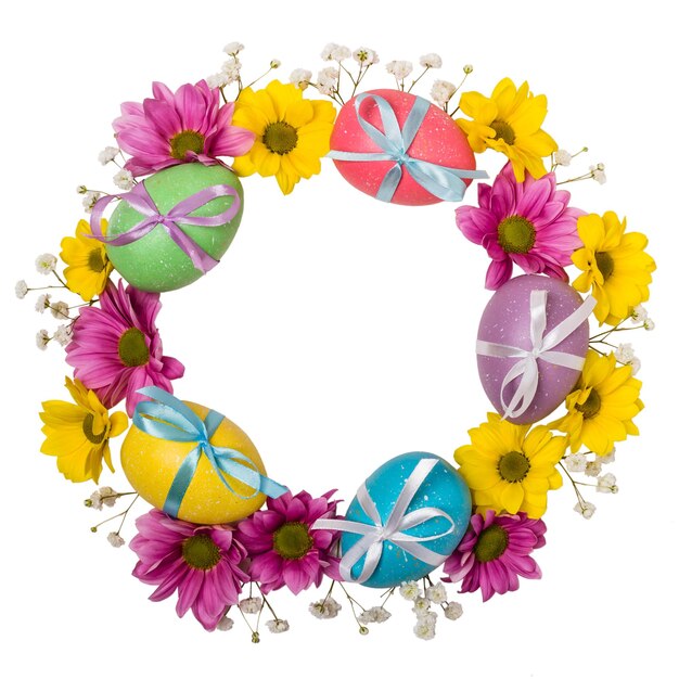 Corona colorata di uova di Pasqua e fiori isolati su sfondo bianco.