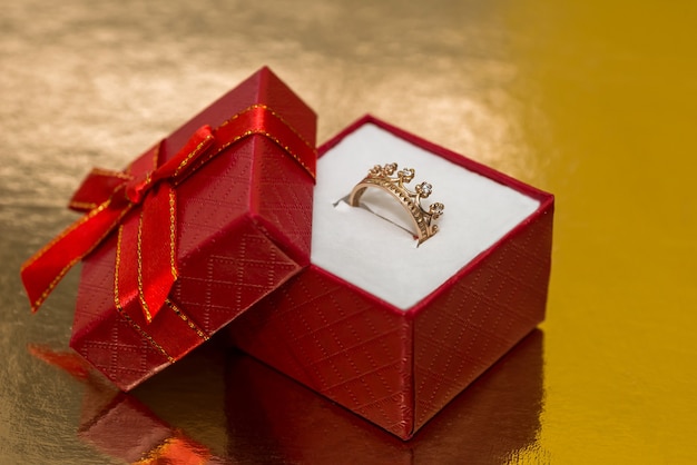 Corona con anello d'oro in scatola regalo rossa