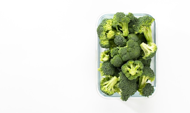 Corona di broccoli lavati e affettati in un contenitore di vetroxBroccoli biologici tagliati a pezzi e pronti per essere utilizzati in cucina