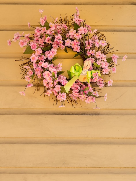 Corona di fiori rosa decorata per pasqua con coniglietto