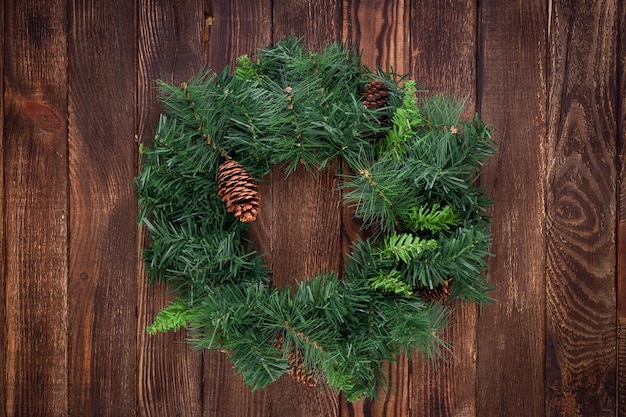 Corona di Natale su fondo di legno. Modello. Biglietto d'auguri.