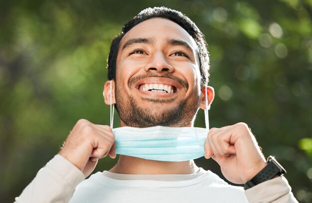 Corona uomo asiatico e togli la maschera per la fine della sicurezza del vaccino pandemico e politica Covid protetta all'aperto Un ragazzo felice e un giapponese rimuovono la copertura del viso per respirare e riducono i tassi di infezione