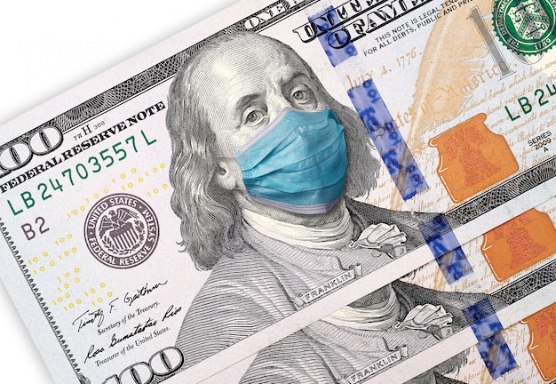Coronavirus COVID-19 negli Stati Uniti, banconota da 100 dollari con maschera facciale. Concetto di crisi e finanza. Isolato su sfondo bianco